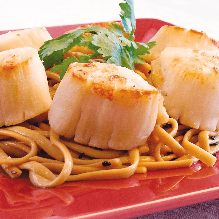 A pile of jumbo sea scallops, fresh and ready to be cooked.