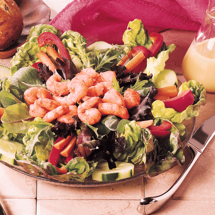 A pile of freshly cooked wild pink shrimp, on a green salad