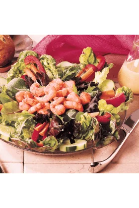 A pile of freshly cooked wild pink shrimp, on a green salad